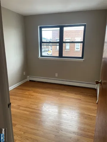 a view of a room with wooden floor and a window