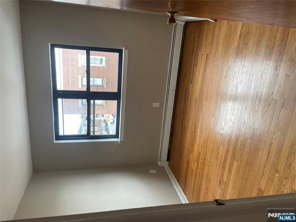 232-230 Anderson Avenue, Unit 3A Fairview, NJ 07022 - Photo 11 of 11 a view of a room with wooden floor and a window