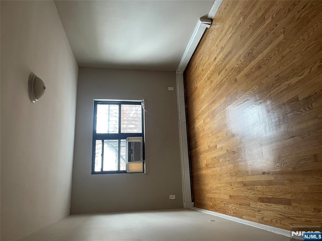 232-230 Anderson Avenue, Unit 3A Fairview, NJ 07022 - Photo 5 of 11 an empty room with wooden floor and windows