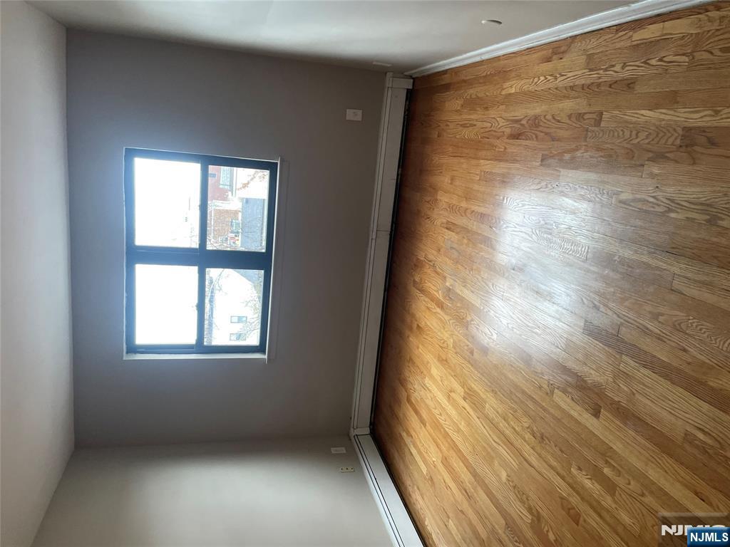 232-230 Anderson Avenue, Unit 3A Fairview, NJ 07022 - Photo 7 of 11 a view of an empty room and wooden floor and a window