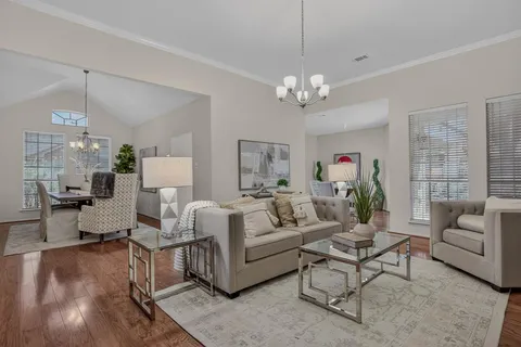 a living room with furniture dining area and a chandelier