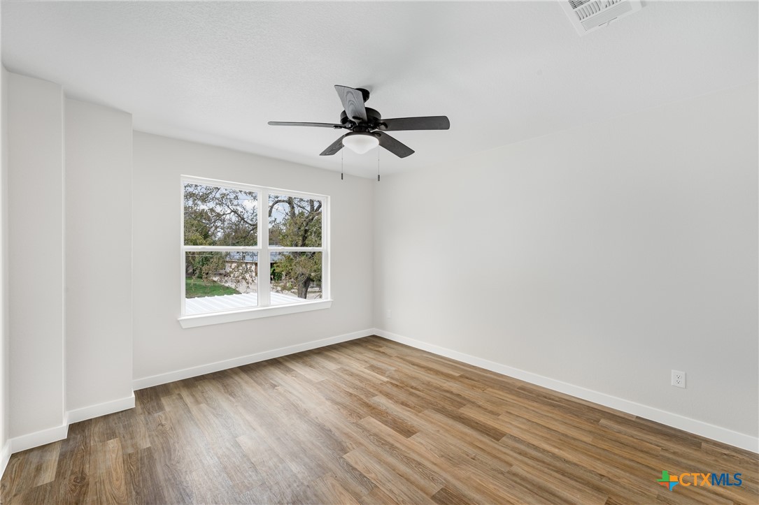 905 Martin Luther King Jr Lane, Unit A Temple, TX 76504 - Photo 13 of 23 wooden floor in an empty room with a window