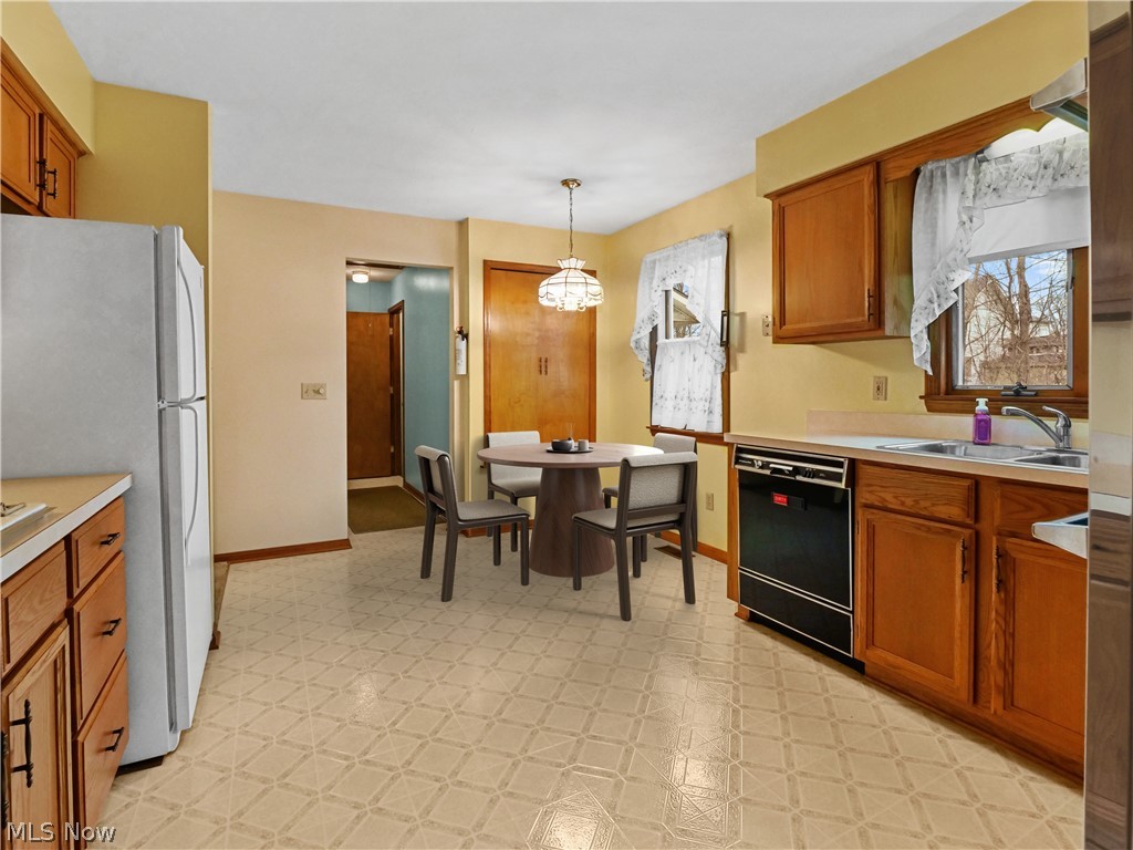 5175 Case Road North Ridgeville, OH 44039 - Photo 9 of 28 Kitchen featuring pendant lighting, sink, light tile floors, black dishwasher, and a notable chandelier