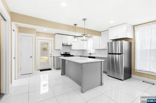 a kitchen with stainless steel appliances granite countertop a refrigerator and a sink
