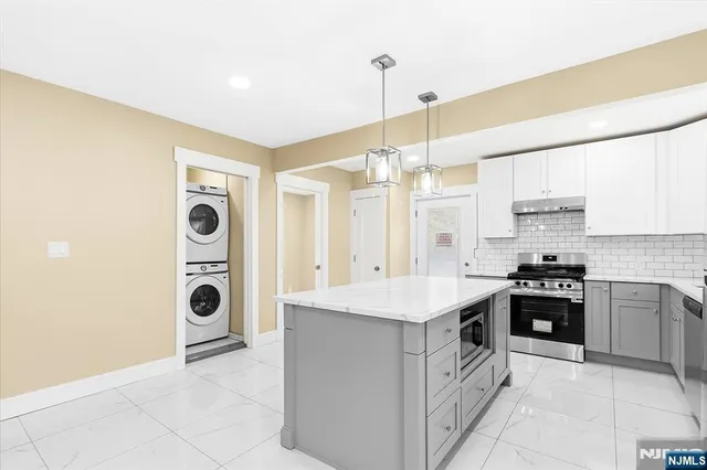 a kitchen with stainless steel appliances granite countertop a stove and a refrigerator