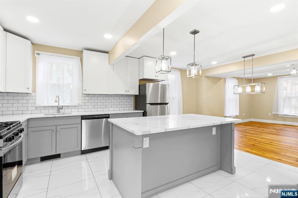 36 Pascack Road, Unit 2 Park Ridge, NJ 07656 - Photo 4 of 22 a kitchen with kitchen island granite countertop a sink a counter top space appliances and cabinets
