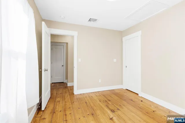 a view of a room with wooden floor and a bathroom