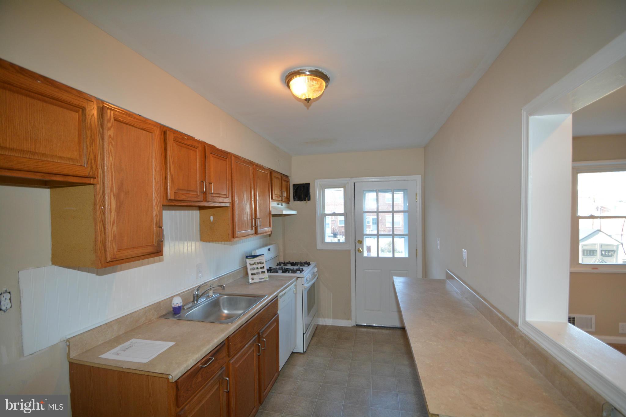 5454 Whitlock Road Baltimore, MD 21229 - Photo 11 of 30 a kitchen with a stove a sink and a refrigerator