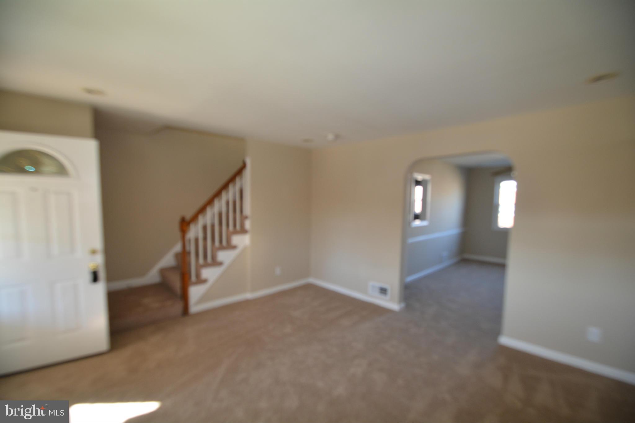 5454 Whitlock Road Baltimore, MD 21229 - Photo 13 of 30 a view of an empty room with stairs and a view of bathroom