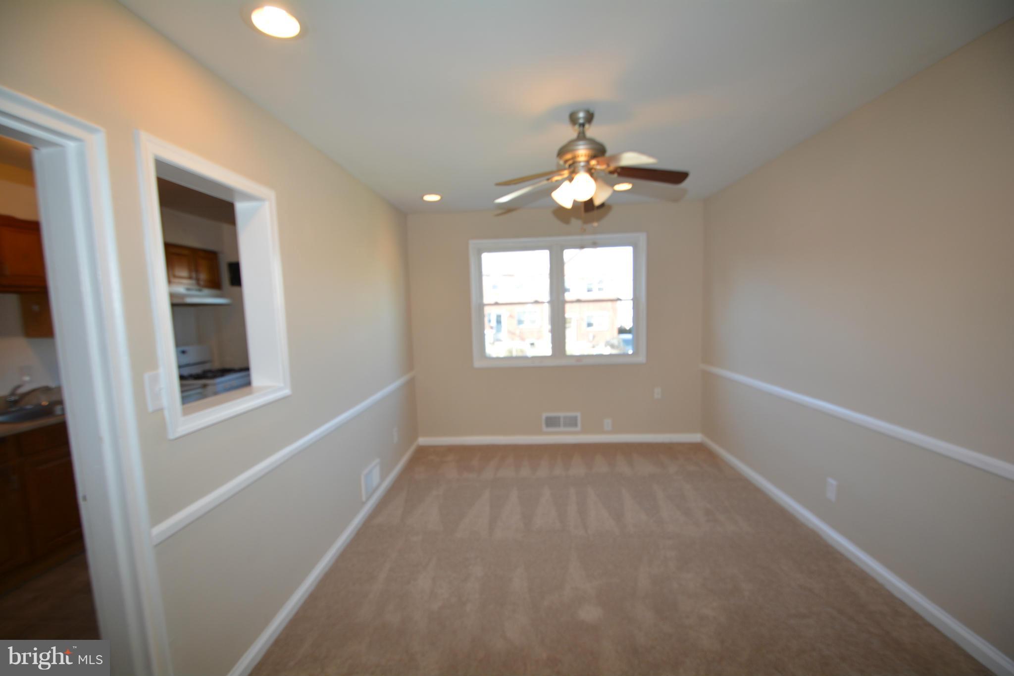 5454 Whitlock Road Baltimore, MD 21229 - Photo 6 of 30 an empty room with windows and chandelier fan