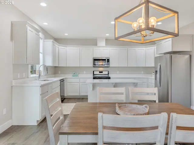 a kitchen with stainless steel appliances granite countertop a stove a sink and a refrigerator