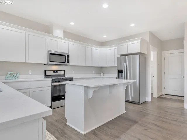 a kitchen with stainless steel appliances a refrigerator stove microwave and sink