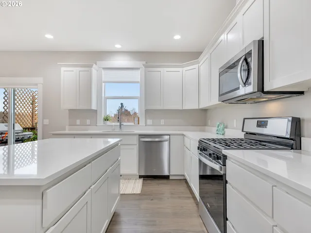 a kitchen with stainless steel appliances granite countertop a sink and a stove