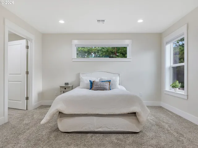 a spacious bedroom with a bed and a window