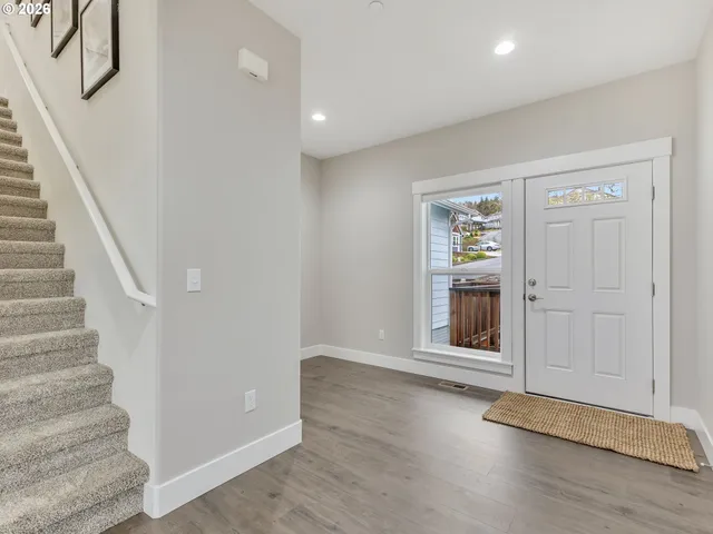 a view of an entryway with wooden floor and door