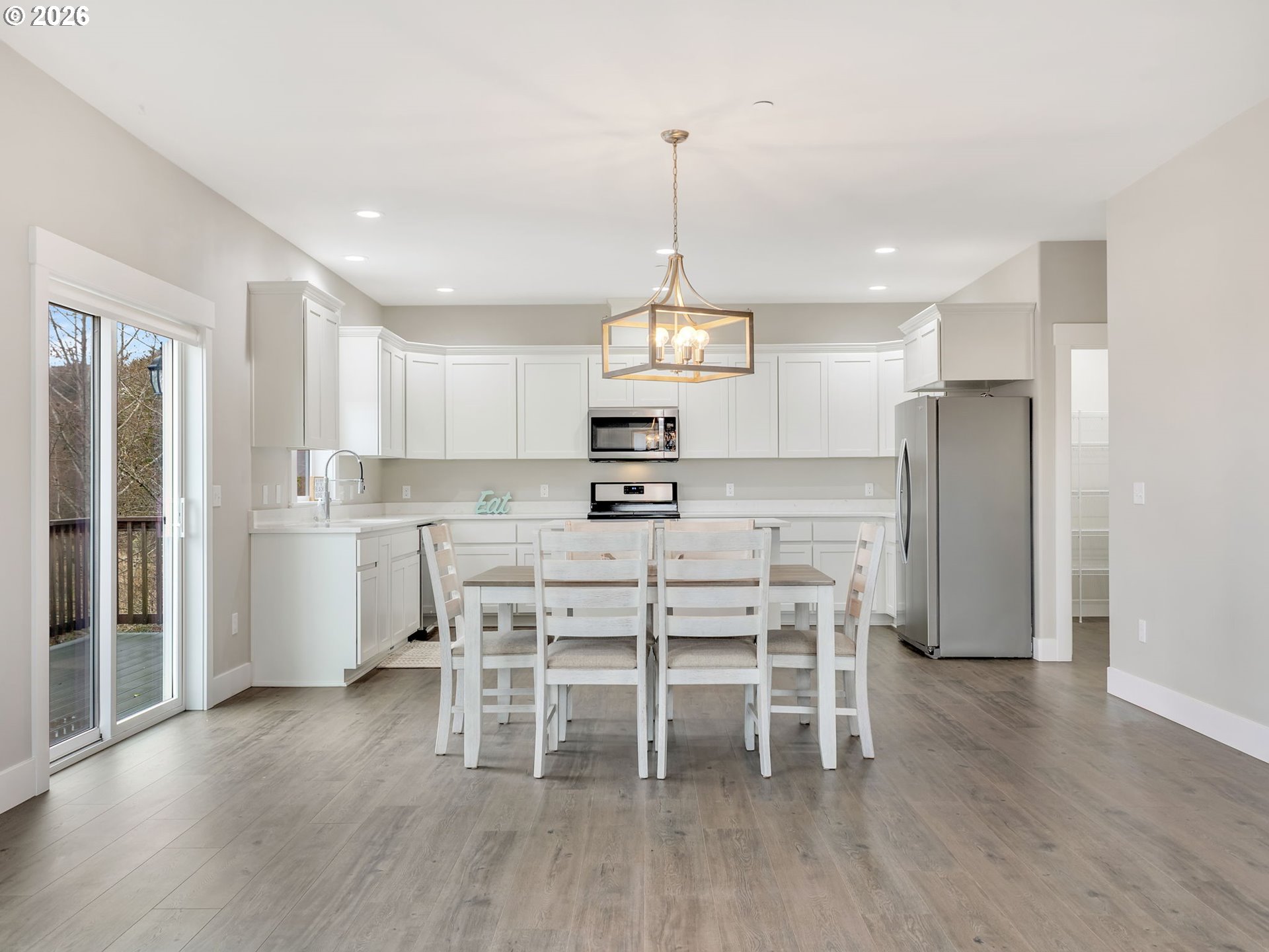 2188 Stanley Lake Court Seaside, OR 97138 - Photo 9 of 46 a kitchen with stainless steel appliances a dining table chairs stove refrigerator and cabinets