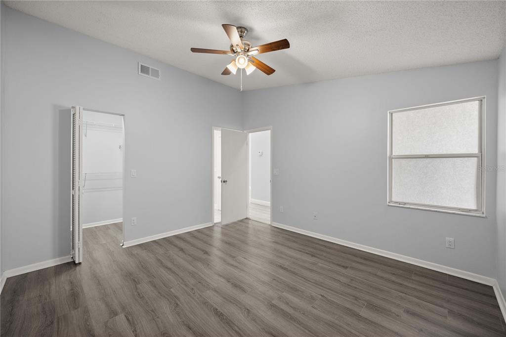 10441 Southwest 85th Court Ocala, FL 34481 - Photo 12 of 32 an empty room with wooden floor and windows