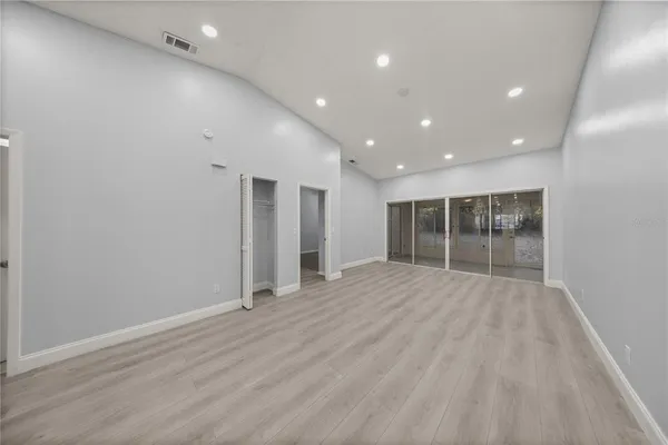 an empty room with wooden floor and windows