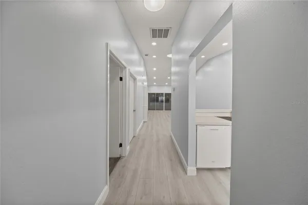 a view of a hallway with wooden floor