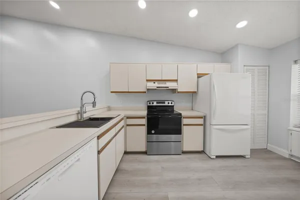 a kitchen with a sink a stove and refrigerator