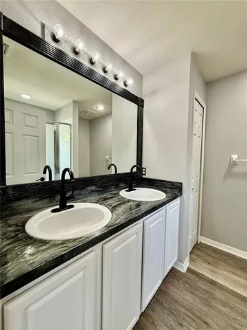 a bathroom with a granite countertop sink mirror and shower