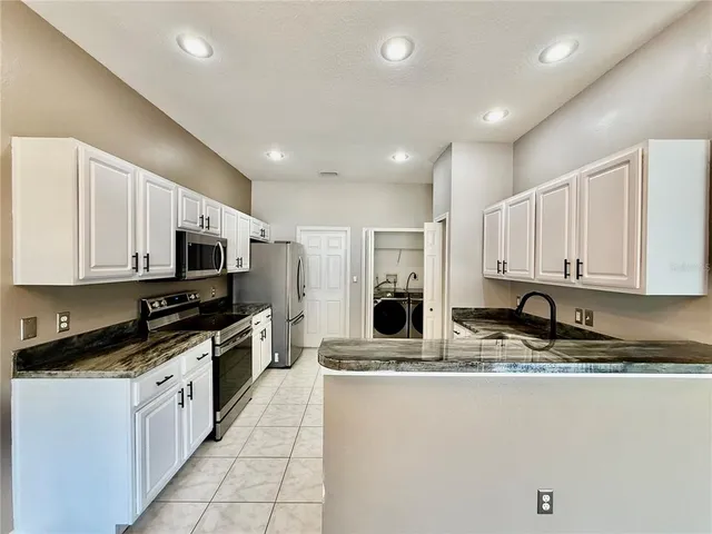 a kitchen with stainless steel appliances a stove a refrigerator and a sink