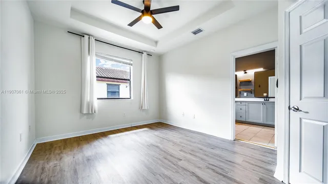 a view of a room with wooden floor and a ceiling fan