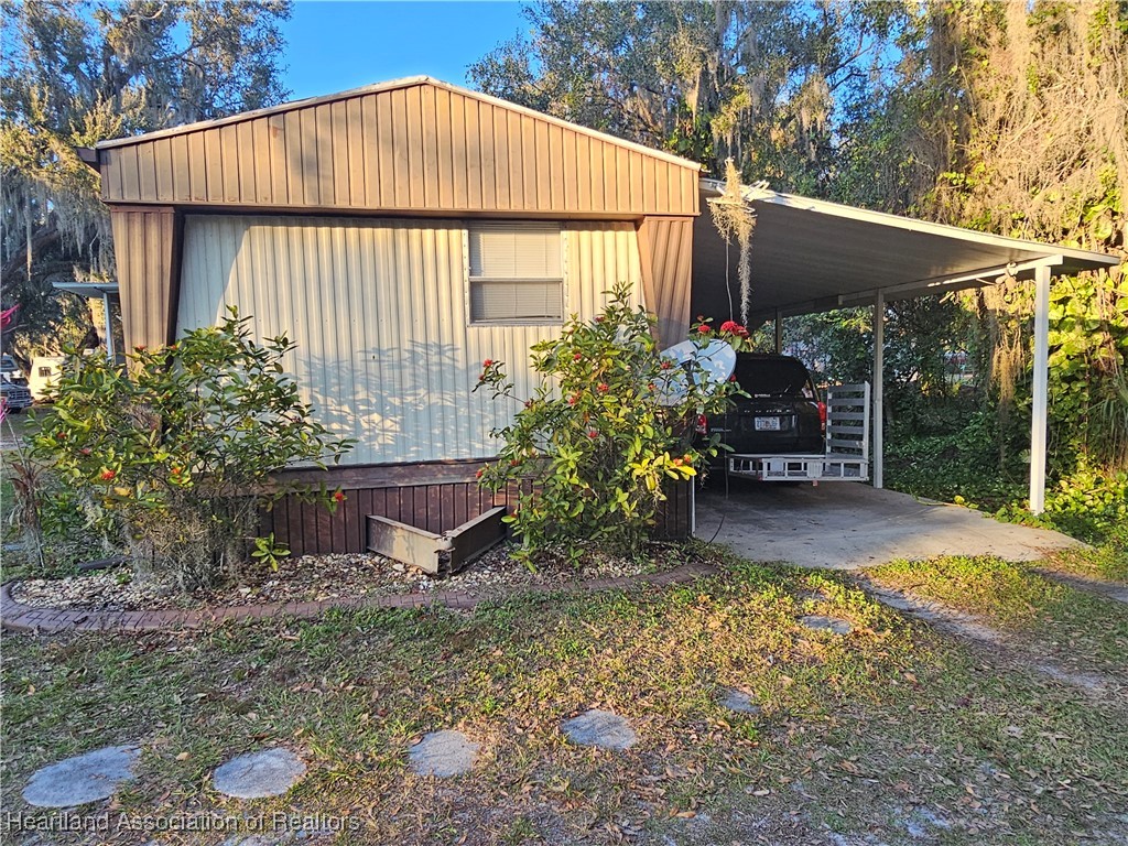 7959 Elliott Road Sebring, FL 33876 - Photo 1 of 31 a backyard of a house with table and chairs under an umbrella