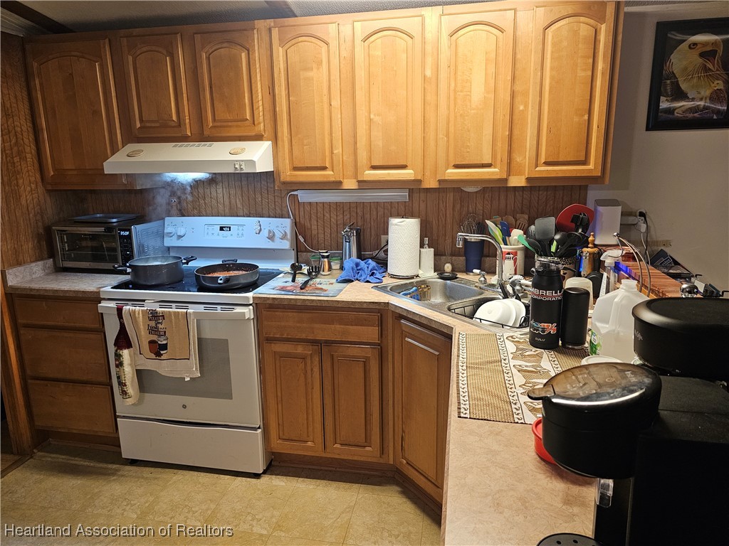 7959 Elliott Road Sebring, FL 33876 - Photo 13 of 31 a kitchen with stainless steel appliances granite countertop a sink stove and cabinets