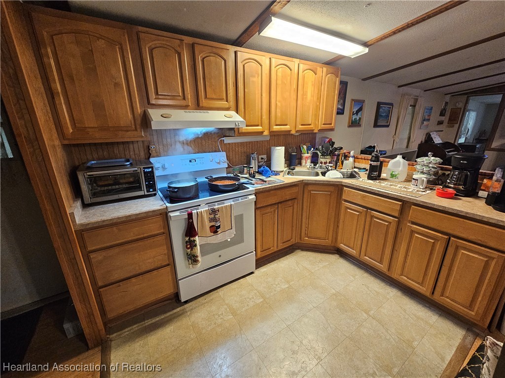 7959 Elliott Road Sebring, FL 33876 - Photo 14 of 31 a kitchen with stainless steel appliances granite countertop a stove a sink dishwasher and cabinets