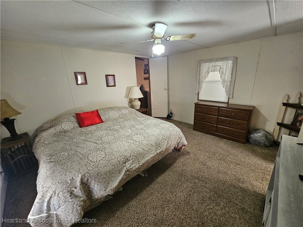 7959 Elliott Road Sebring, FL 33876 - Photo 17 of 31 a bedroom with a bed and a chandelier