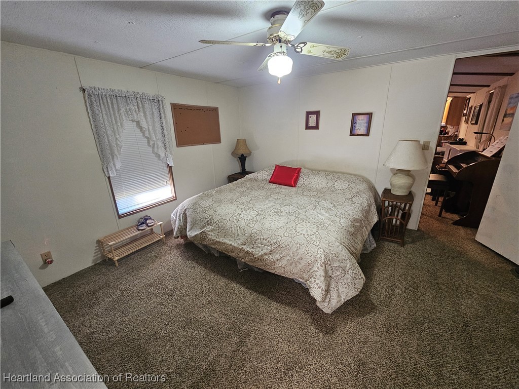 7959 Elliott Road Sebring, FL 33876 - Photo 18 of 31 a bed room with a bed and a chandelier