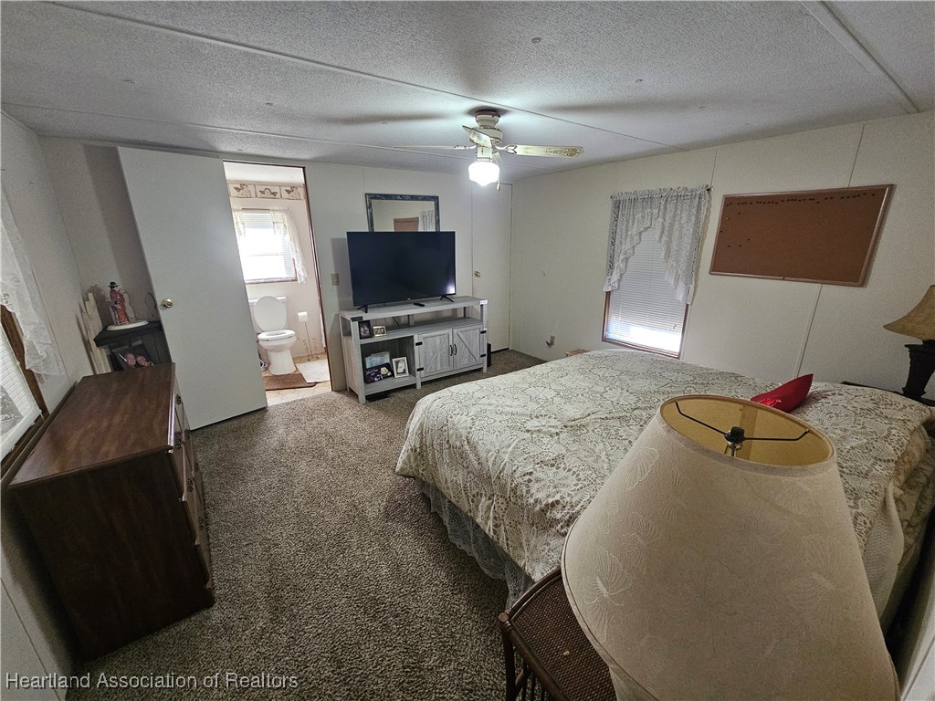 7959 Elliott Road Sebring, FL 33876 - Photo 19 of 31 a spacious bedroom with a bed and a flat screen tv