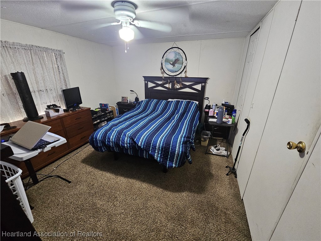 7959 Elliott Road Sebring, FL 33876 - Photo 25 of 31 a bedroom with bed and a chandelier
