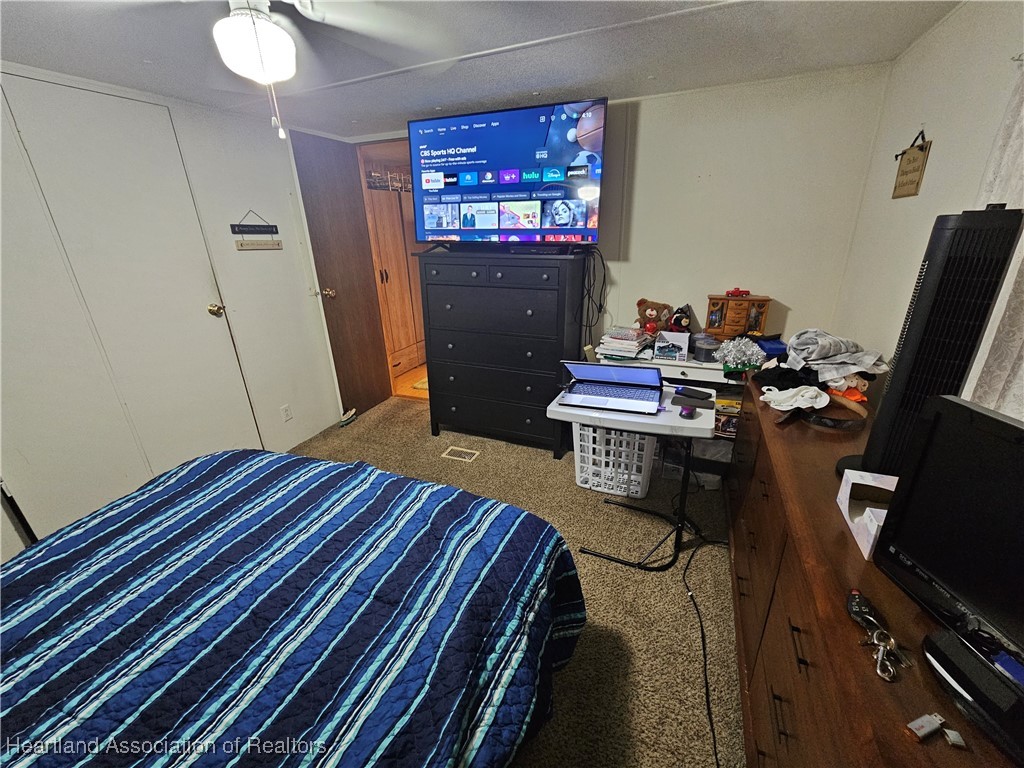 7959 Elliott Road Sebring, FL 33876 - Photo 26 of 31 a bedroom with a bed and wooden floor