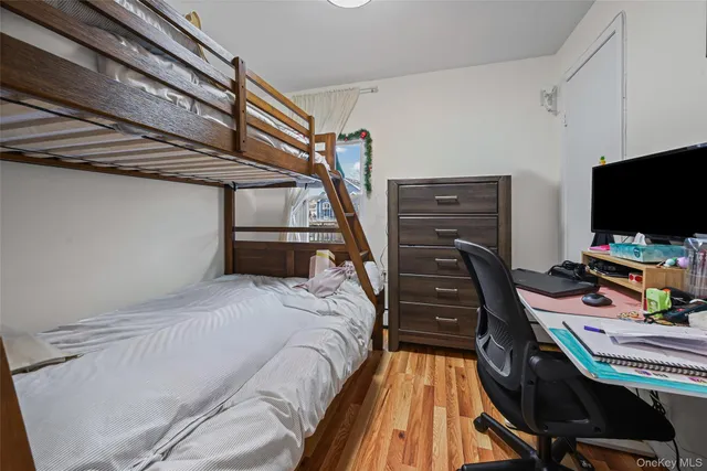 a bedroom with a bed and a flat tv screen on a dresser
