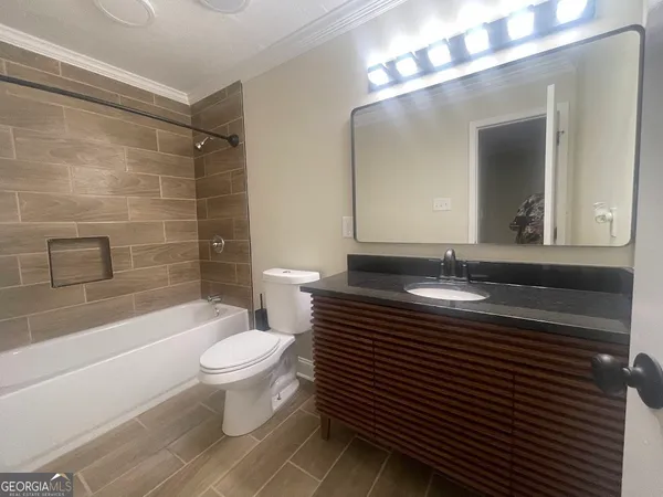 a bathroom with a sink a toilet a mirror and bathtub