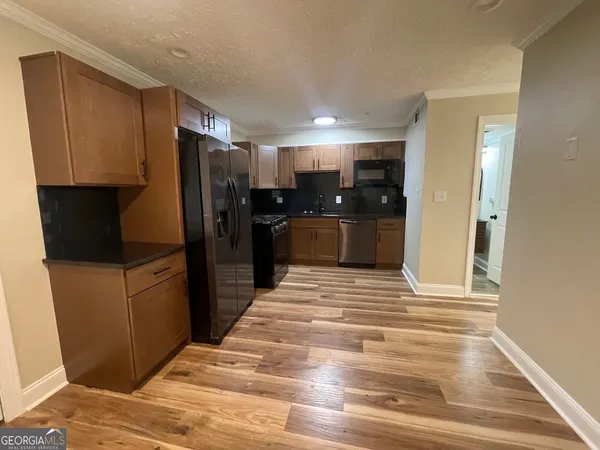 a kitchen with stainless steel appliances kitchen island granite countertop a refrigerator and a sink