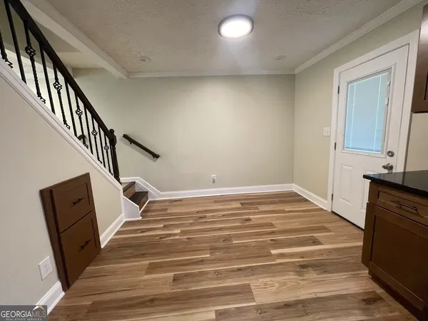 a view of a livingroom with wooden floor and staircase