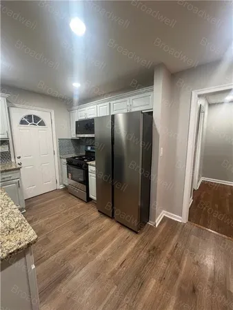 a view of a refrigerator in kitchen and wooden floor