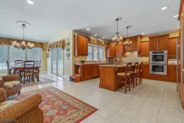 a open kitchen with stainless steel appliances granite countertop a stove top oven a sink dishwasher and a dining table with granite countertops
