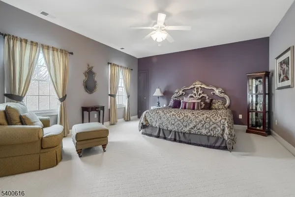 a bedroom with a bed a couch and a chandelier