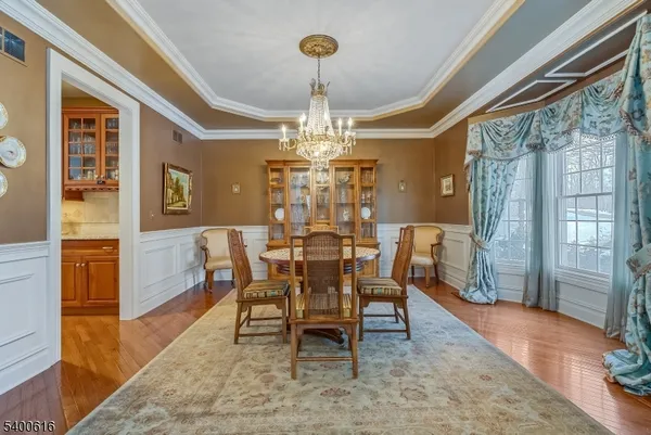 a dining room with furniture a chandelier and wooden floor