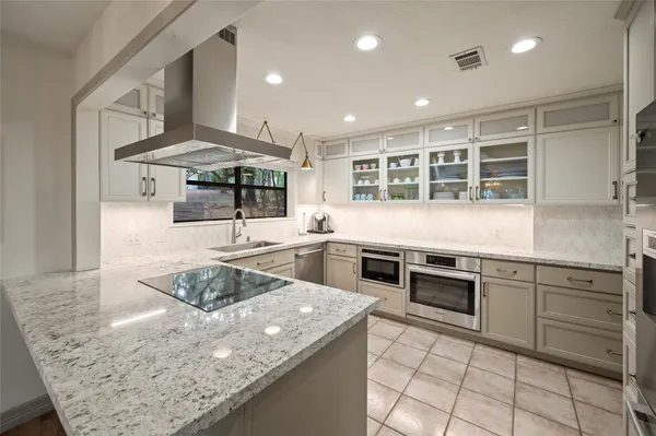 a kitchen with stainless steel appliances granite countertop a sink and stove