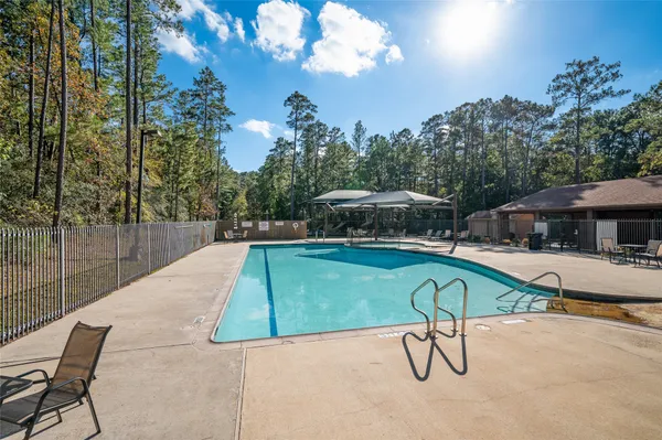 a view of a swimming pool with a table and chairs under an umbrella