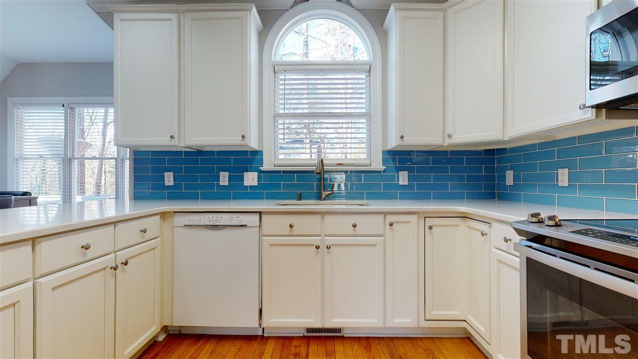 4708 Alistar Court Raleigh, NC 27612 - Photo 14 of 30 a kitchen with granite countertop white cabinets and white appliances