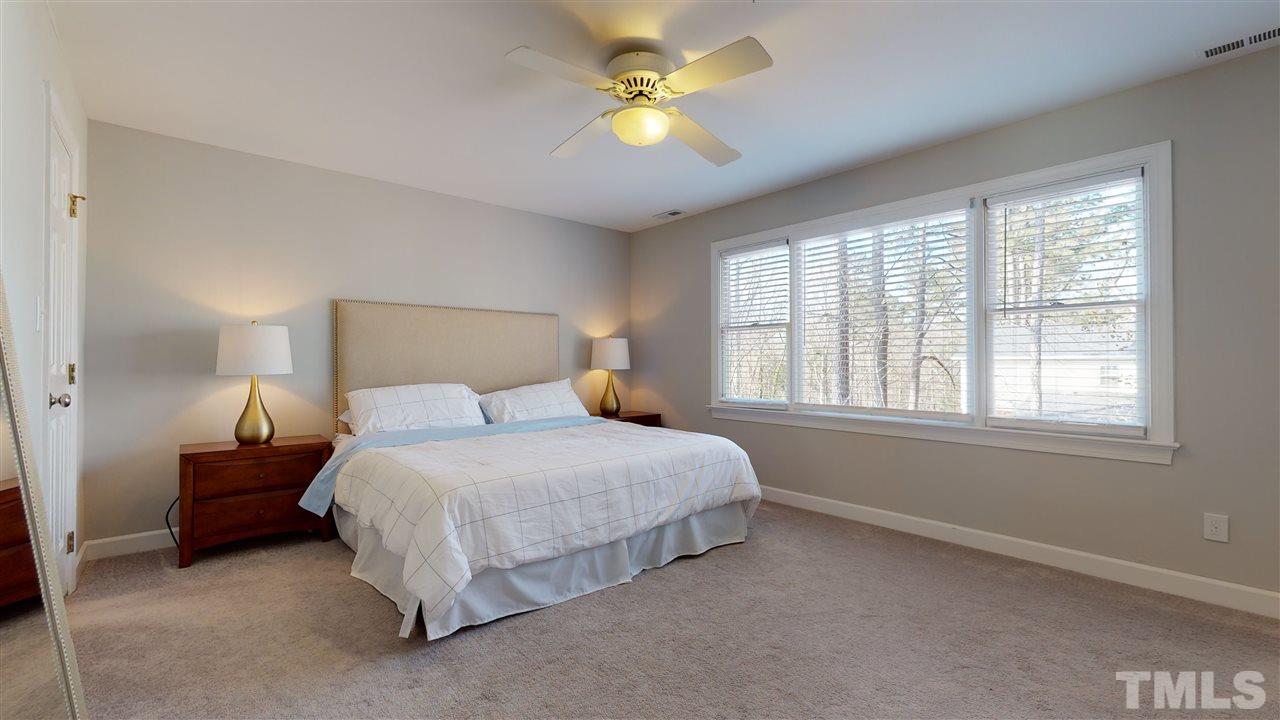 4708 Alistar Court Raleigh, NC 27612 - Photo 18 of 30 a bedroom with a bed and a chandelier fan