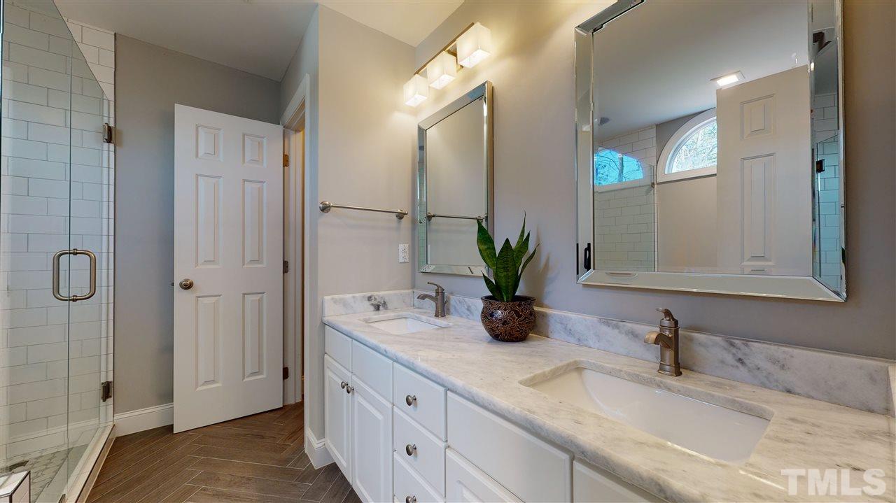 4708 Alistar Court Raleigh, NC 27612 - Photo 19 of 30 a bathroom with a granite countertop sink and a mirror