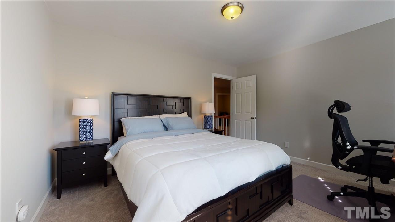 4708 Alistar Court Raleigh, NC 27612 - Photo 22 of 30 a bedroom with a bed and a lamp on the dresser