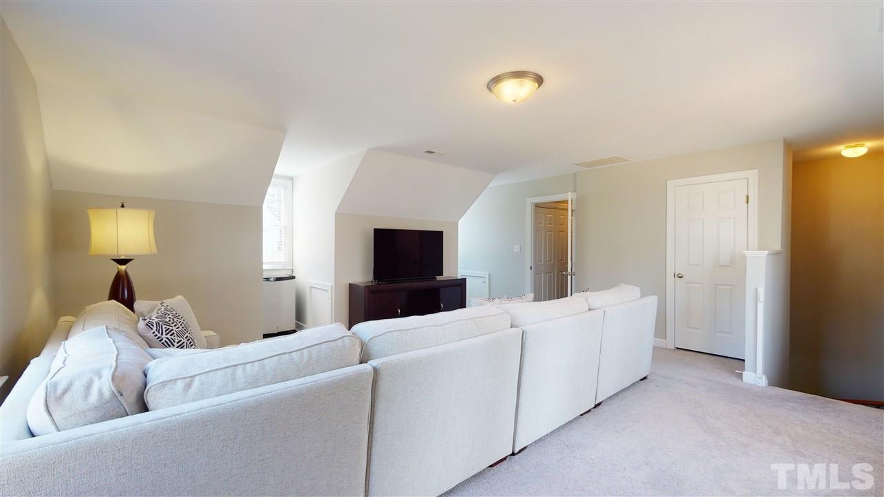 4708 Alistar Court Raleigh, NC 27612 - Photo 25 of 30 a living room with furniture and a flat screen tv